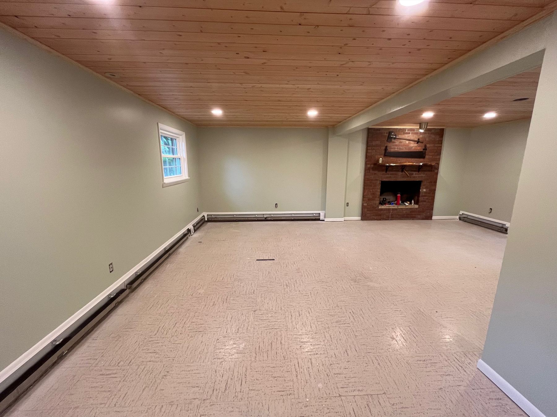 Open family room with pine ceiling and brick fireplace