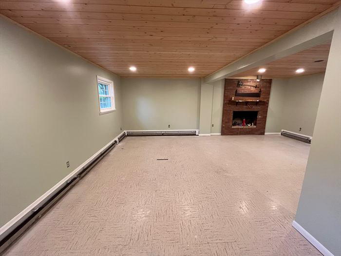 Open family room with pine ceiling and brick fireplace