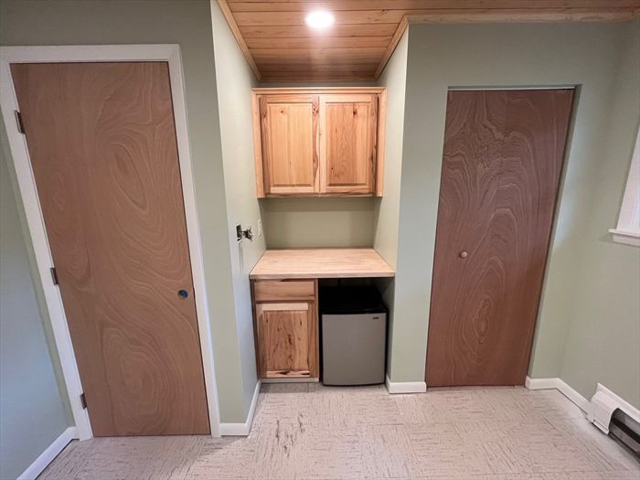 Bar nook with cabinets and beverage fridge