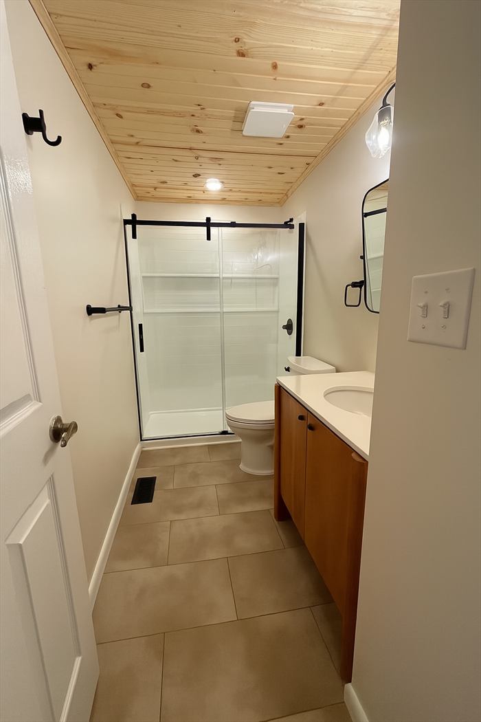Glass shower door and wood vanity
